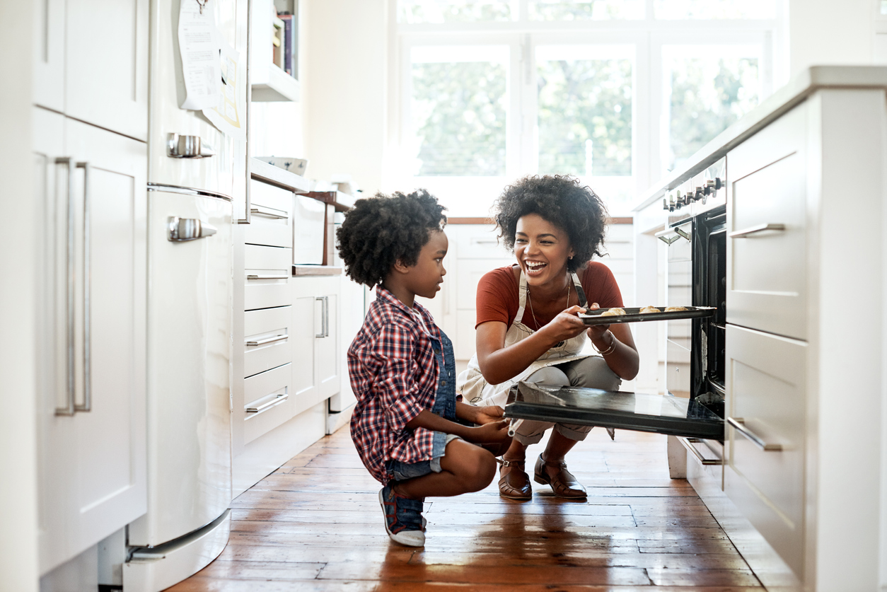 A parent and child cooking together in a kitchen