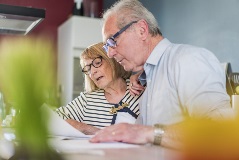 An elderly couple budgeting finances