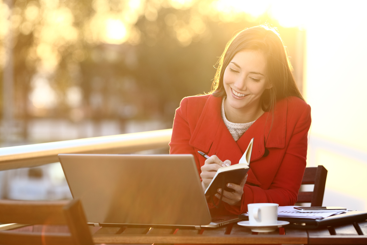 Woman sitting outside looking at computer - golden hour