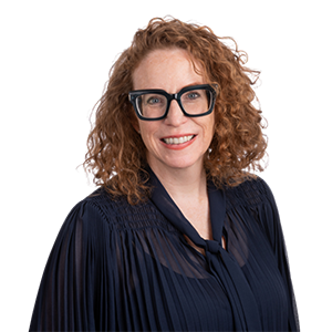 Wendy Brookhouse headshot. She is wearing a dark shirt and has dark glasses. She is smiling at the  camera