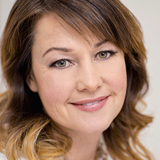 Zena Amundsen headshot. She is smiling warmly at the camera and has light brown hair